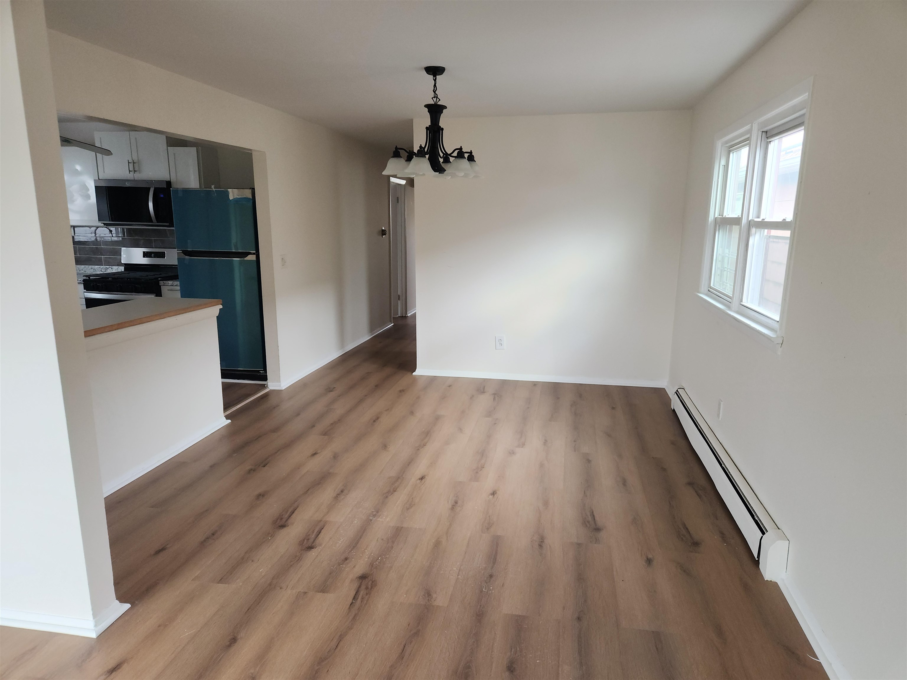 71 Linnet Street, Unit 2 Bayonne, NJ 07002 - Photo 6 of 18 an empty room with wooden floor a ceiling fan and windows