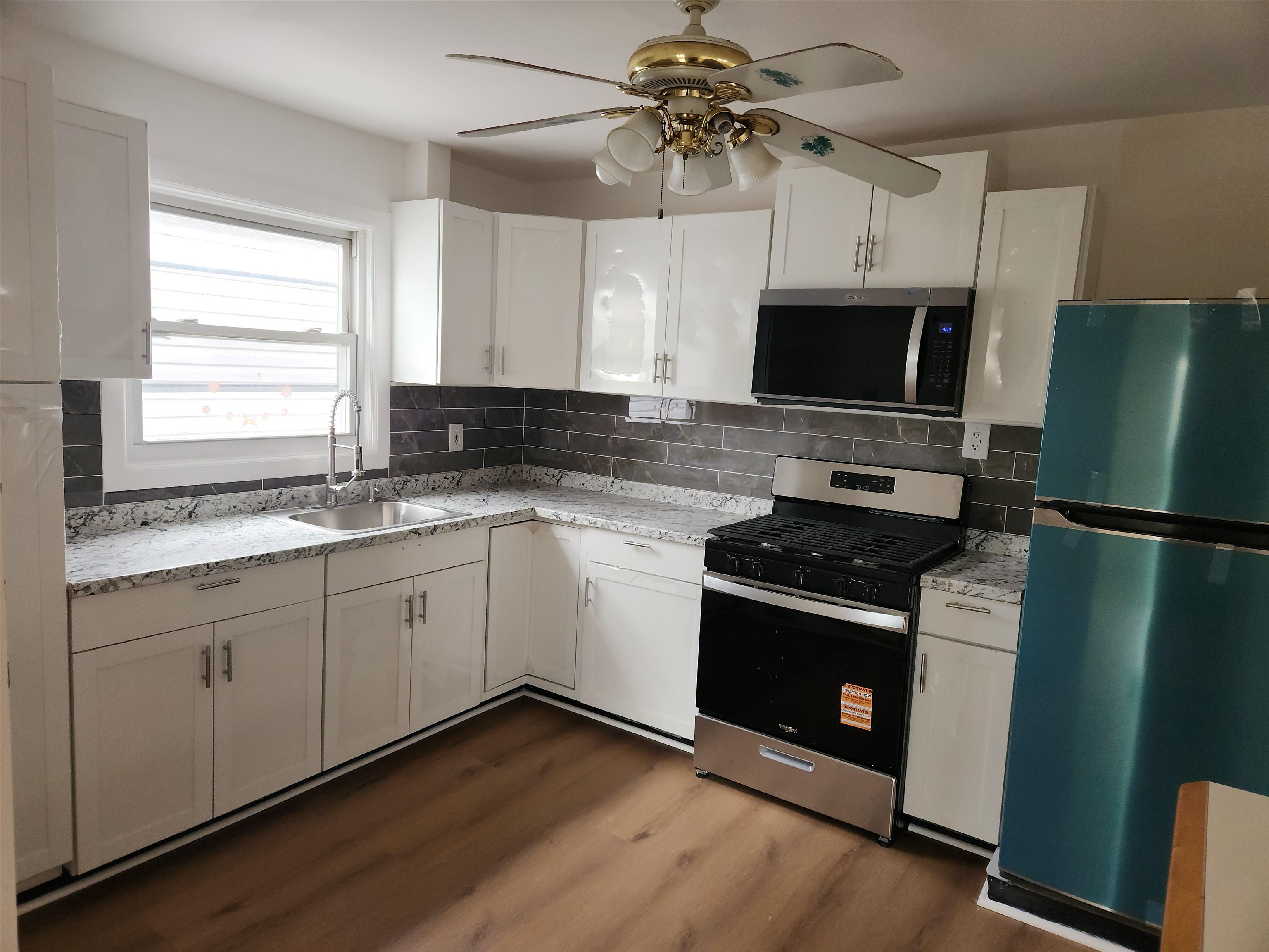 71 Linnet Street, Unit 2 Bayonne, NJ 07002 - Photo 8 of 18 a kitchen with stainless steel appliances white cabinets and a sink