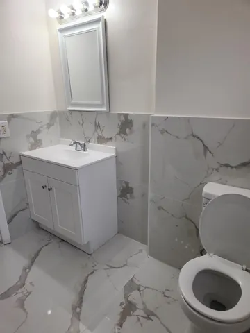 a bathroom with a toilet sink and mirror