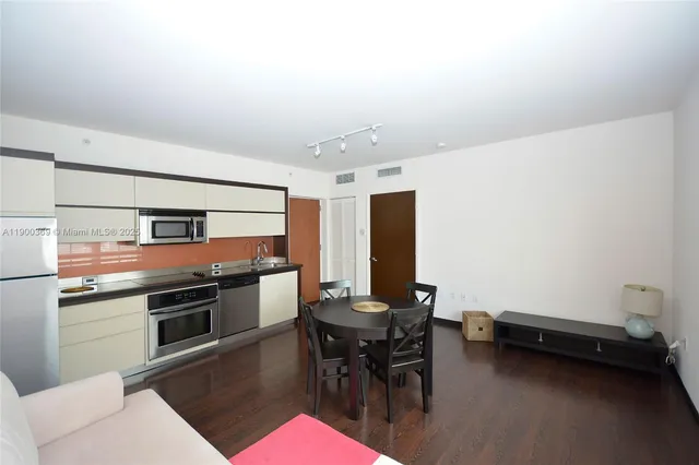 a kitchen with stainless steel appliances kitchen island granite countertop a sink and cabinets