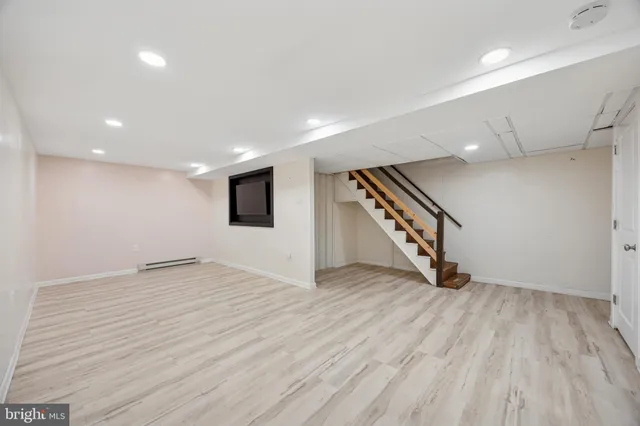 an empty room with wooden floor and entryway