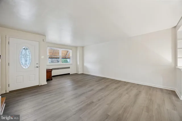 an empty room with wooden floor and window