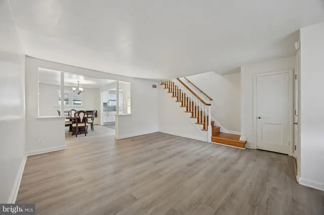 a view of empty room with wooden floor and stairs
