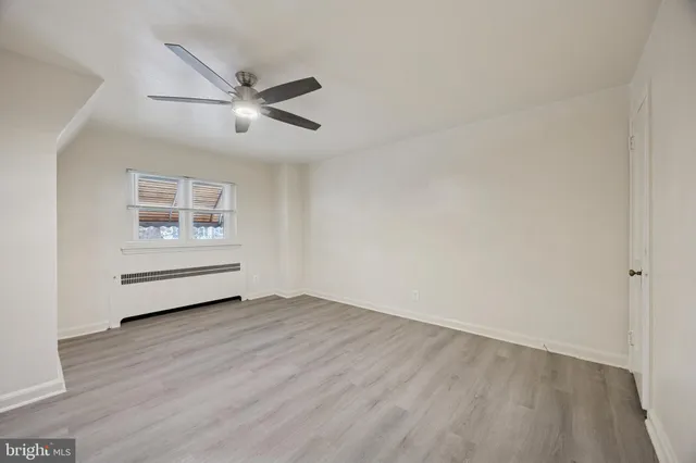 an empty room with windows and ceiling fan