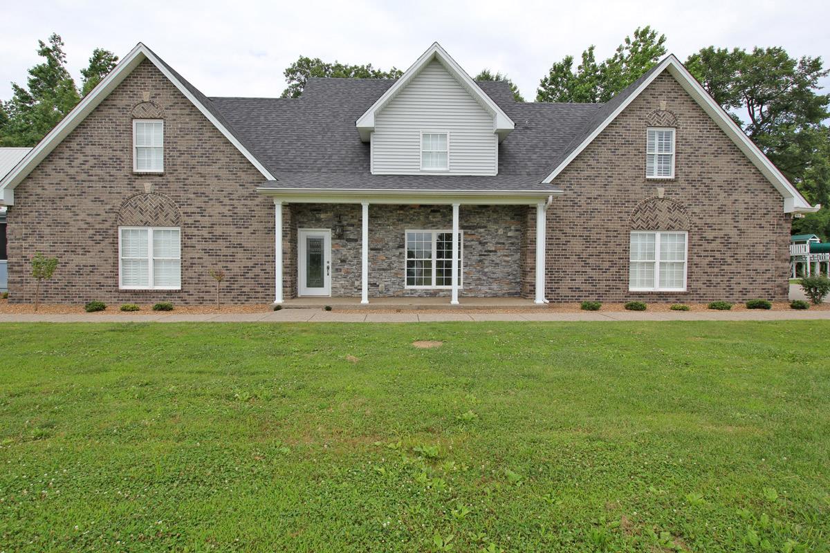 a view of a brick house with a yard