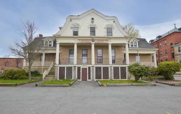 a view of a brick house with a yard and large windows