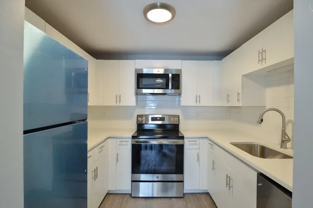 a kitchen with a refrigerator sink and stove top oven