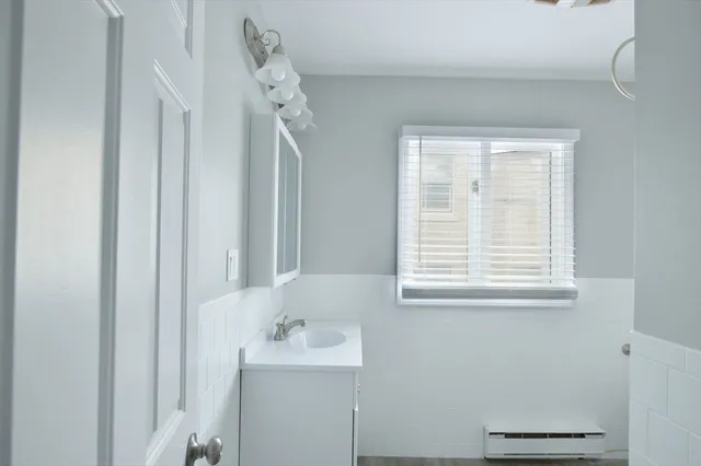 a bathroom with a sink a mirror and a window