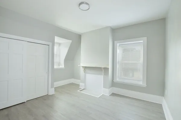 an empty room with windows and cabinet