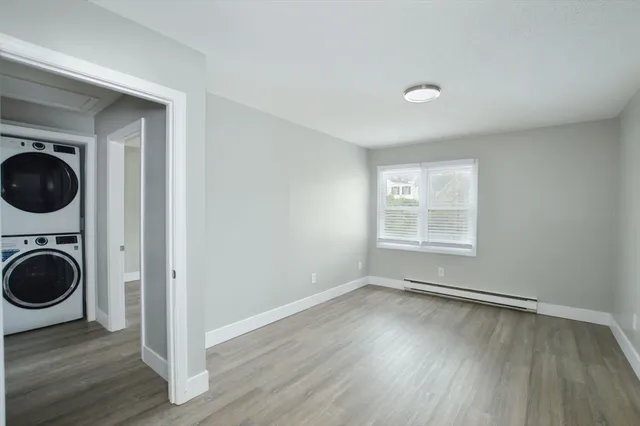 a view of a hallway with wooden floor and a window