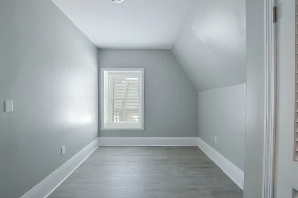 a view of empty room with wooden floor