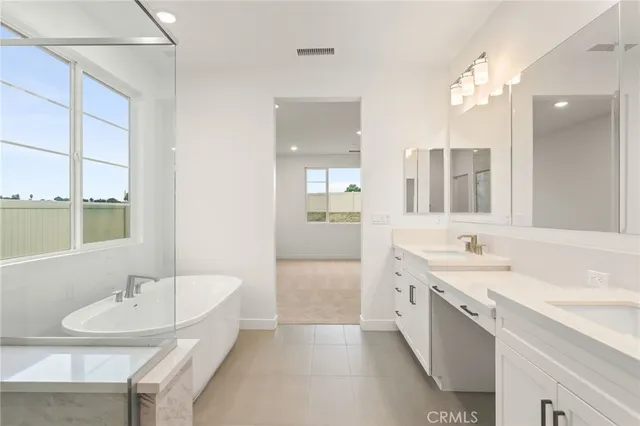 a bathroom with a granite countertop sink a large mirror and a bathtub