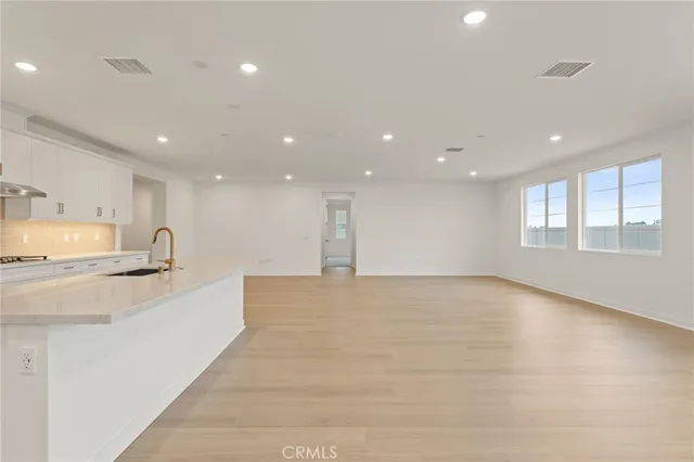 a large kitchen with stainless steel appliances lots of counter top space and windows