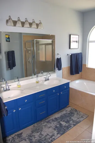 a bathroom with a tub double sink and mirror