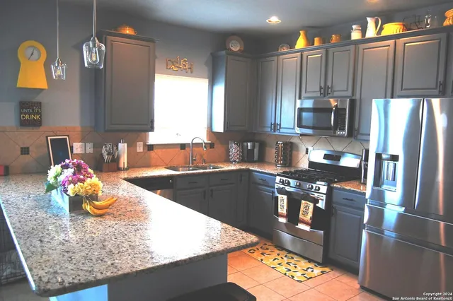 a kitchen with stainless steel appliances granite countertop a refrigerator stove and sink