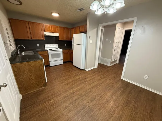 a view of kitchen with sink and refrigerator