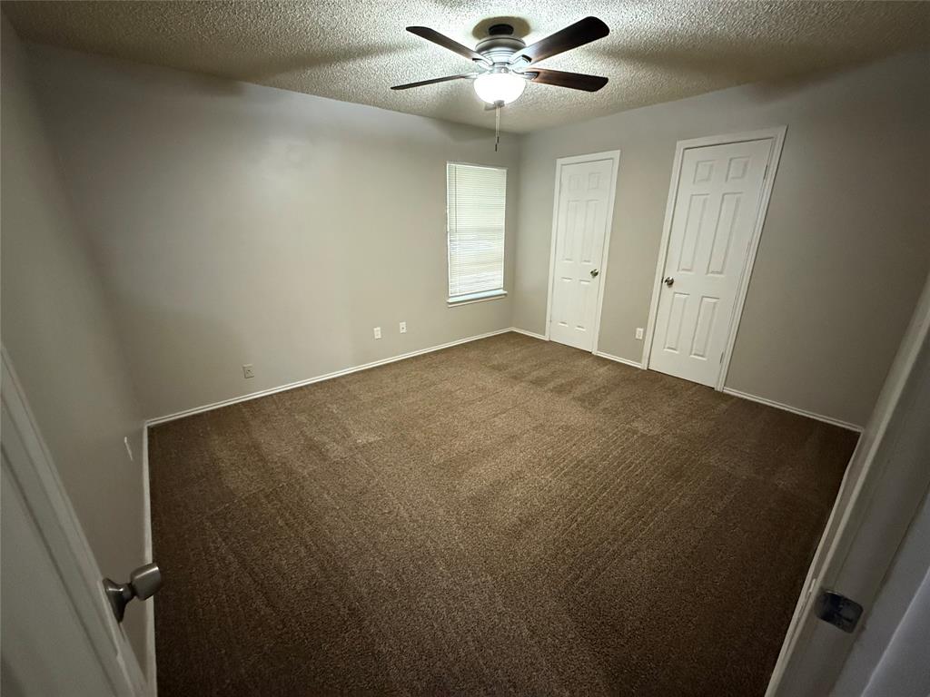 1610 Sun Valley Drive, Unit A Cleburne, TX 76033 - Photo 5 of 8 an empty room with windows and fan