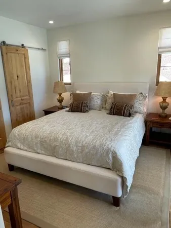 a large bed sitting in a bedroom next to a window