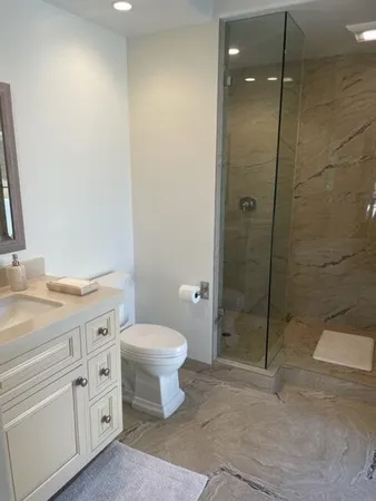 a bathroom with a granite countertop sink toilet and shower