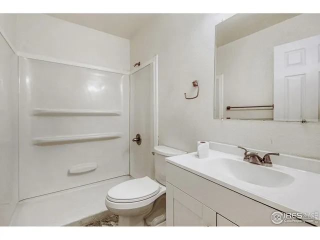 a bathroom with a sink toilet vanity and shower