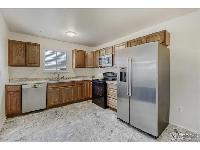 a kitchen with a refrigerator sink and cabinets