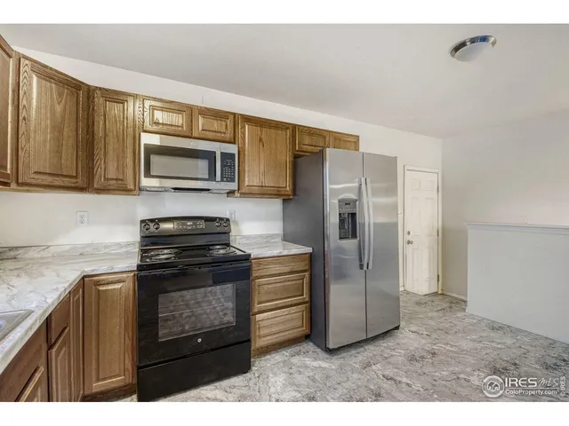 a kitchen with stainless steel appliances granite countertop a refrigerator stove and microwave