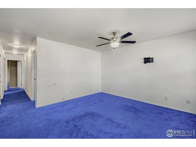 a view of room with hardwood floor and a ceiling fan