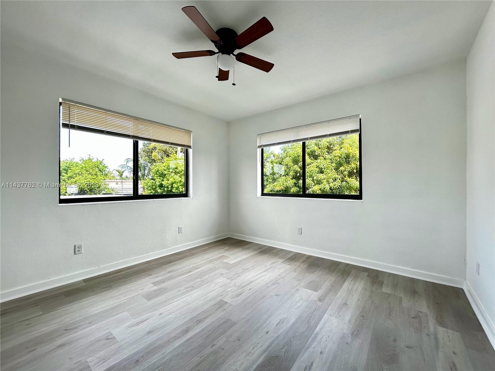 875 80th Street, Unit 3 Miami Beach, FL 33141 - Photo 11 of 15 a view of an empty room with wooden floor and a window