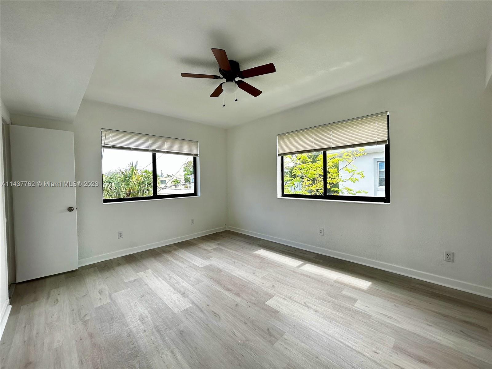 875 80th Street, Unit 3 Miami Beach, FL 33141 - Photo 13 of 15 a view of an empty room with wooden floor and a window