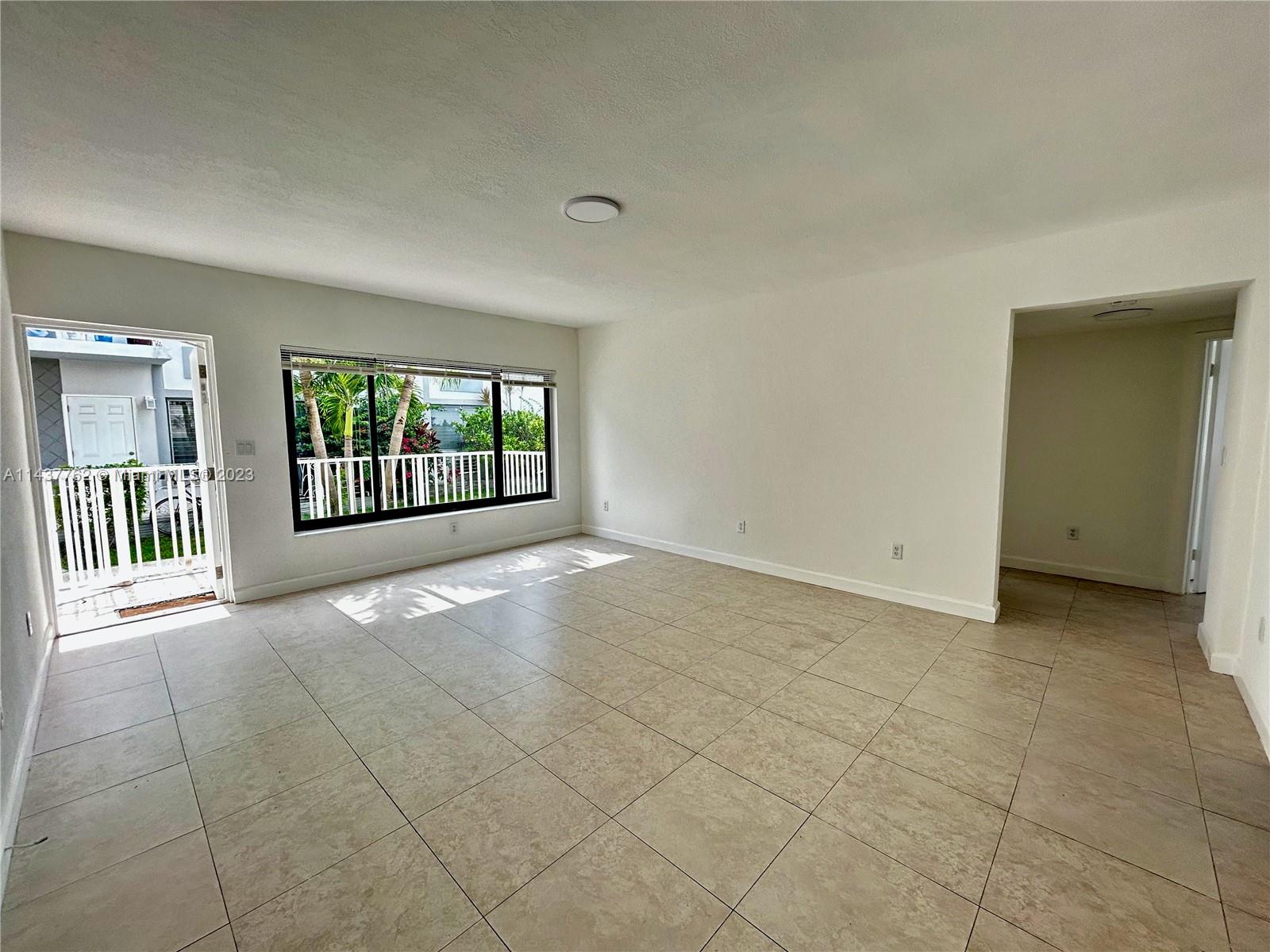 875 80th Street, Unit 3 Miami Beach, FL 33141 - Photo 2 of 15 a view of a livingroom with an empty space and a window