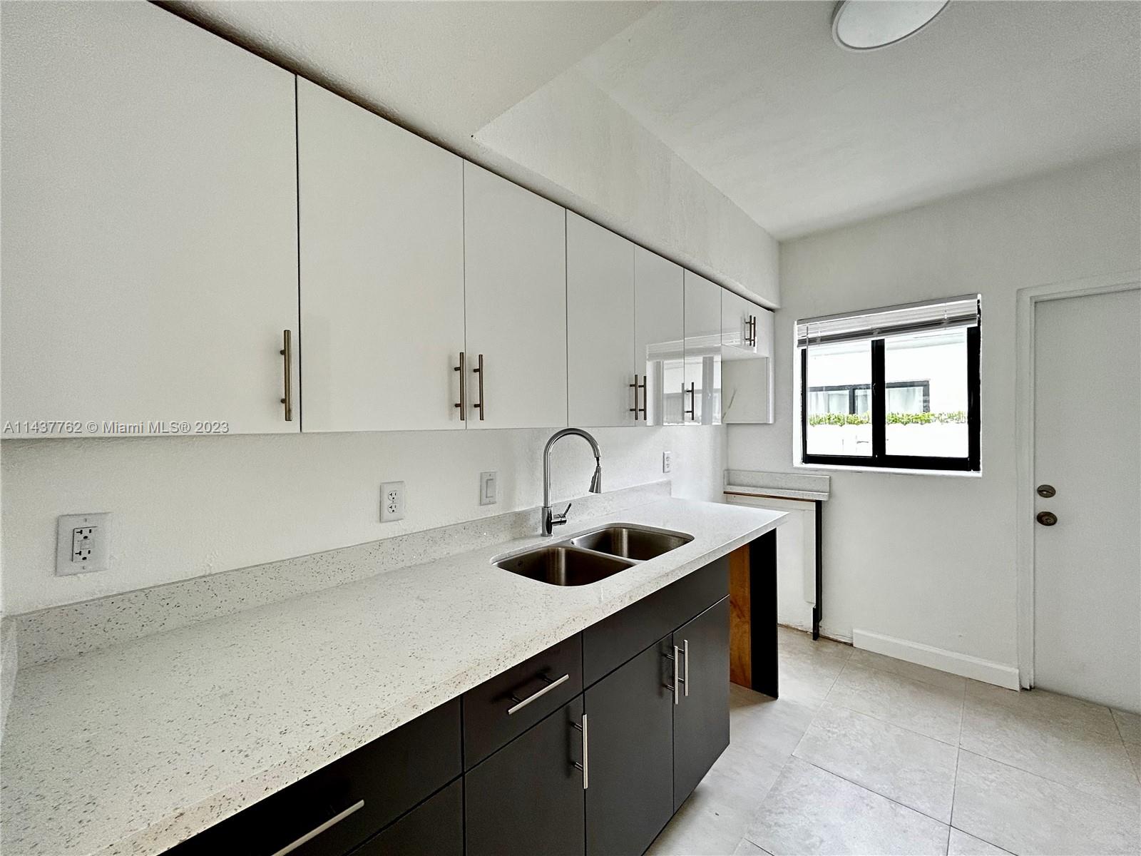 875 80th Street, Unit 3 Miami Beach, FL 33141 - Photo 3 of 15 a kitchen with a sink and cabinets