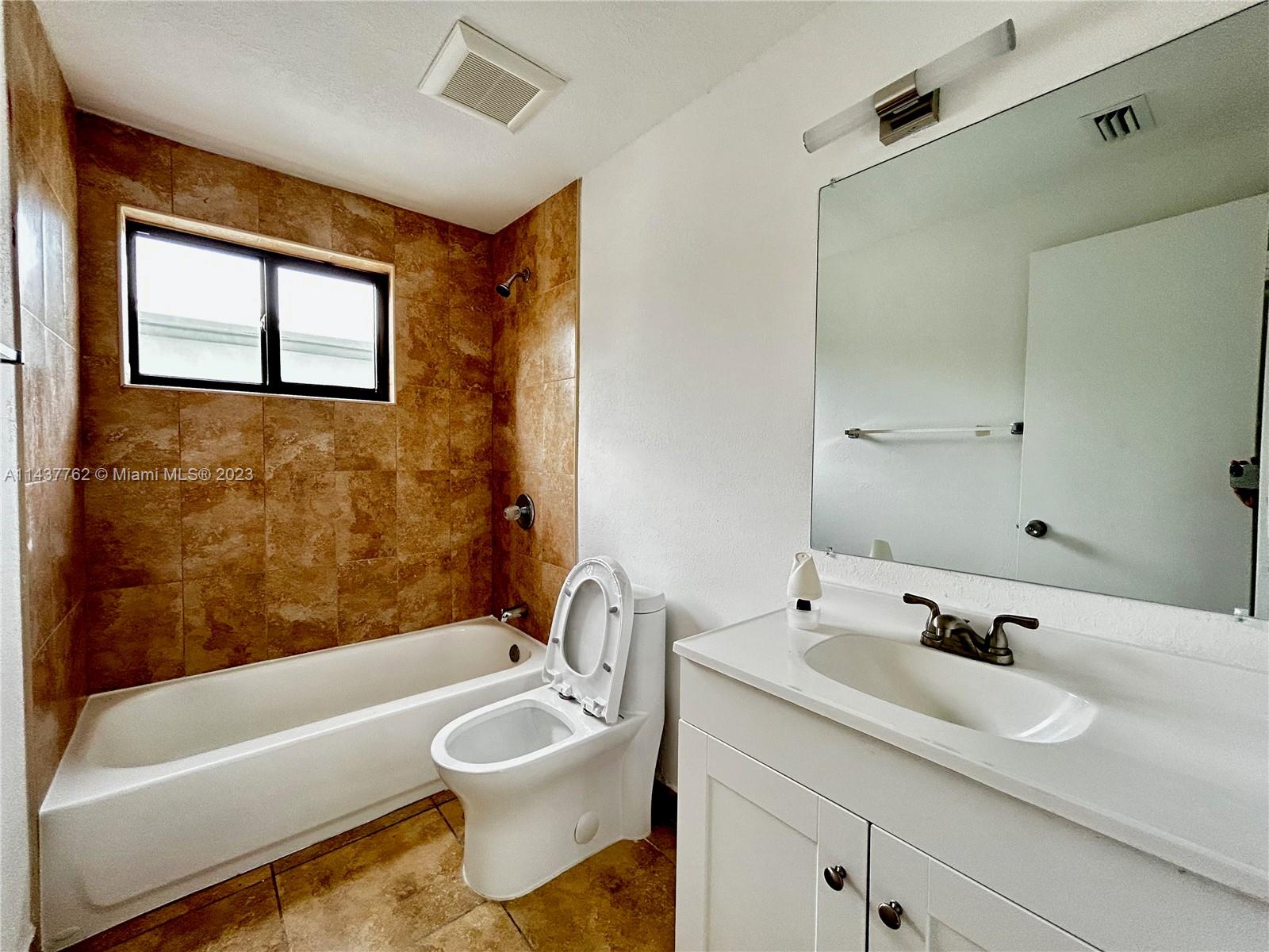 875 80th Street, Unit 3 Miami Beach, FL 33141 - Photo 7 of 15 a bathroom with a sink a toilet and a bathtub