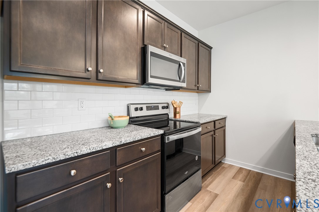 11348 Benton Pointe Way Chester, VA 23831 - Photo 19 of 45 a kitchen with stainless steel appliances granite countertop a sink a stove and a microwave