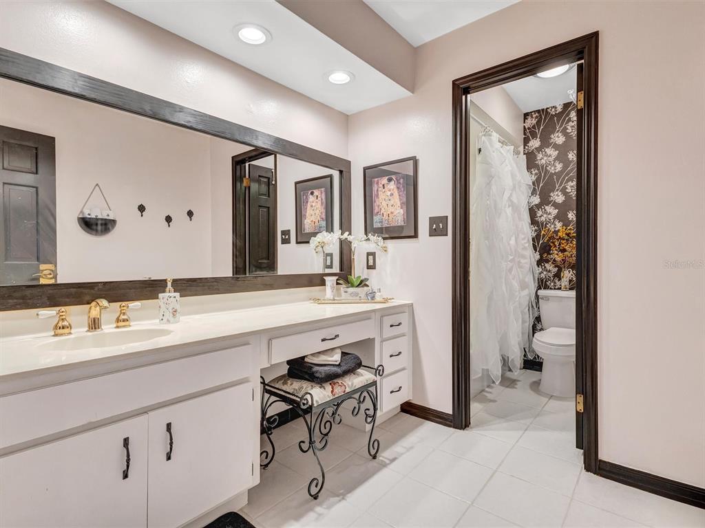 7581 Cumberland Road, Unit 7 Seminole, FL 33777 - Photo 31 of 68 a bathroom with a sink a toilet and a large mirror
