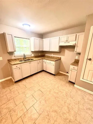 a kitchen with stainless steel appliances a sink a stove a counter top space and cabinets