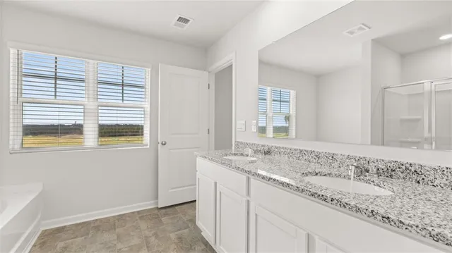 a bathroom with a granite countertop sink and a window