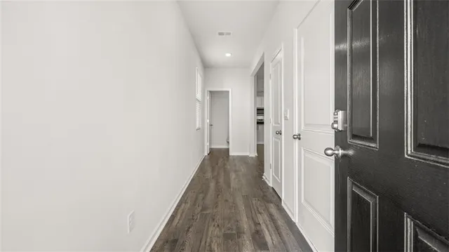 a view of a hallway with wooden floor and staircase