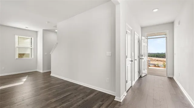 a view of a hallway with wooden floor and a living room
