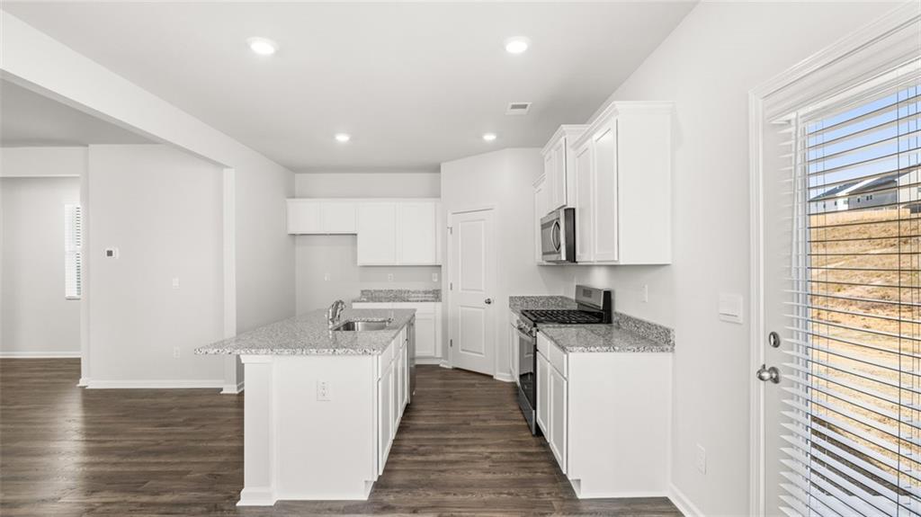 177 Lauritsen Way Newnan, GA 30265 - Photo 7 of 37 a kitchen with stainless steel appliances a sink stove and cabinets