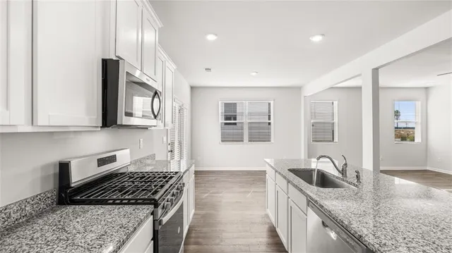 a kitchen that has a sink a stove and cabinets