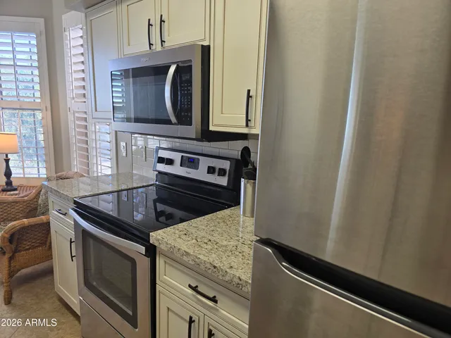 a kitchen with granite countertop a stove and a microwave
