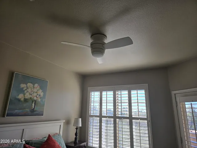 a bedroom with a bed and a lamp on dresser