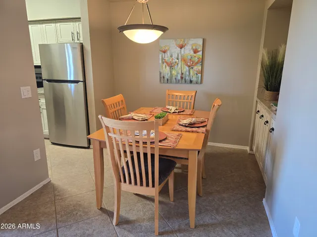 a dining room with furniture and a refrigerator