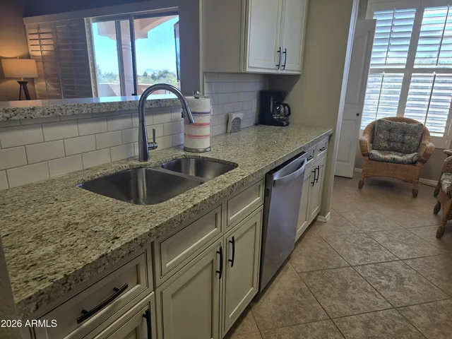 a kitchen with granite countertop a sink and a window