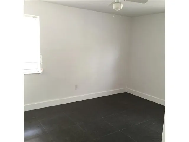 a view of a small space with wooden floor and a window