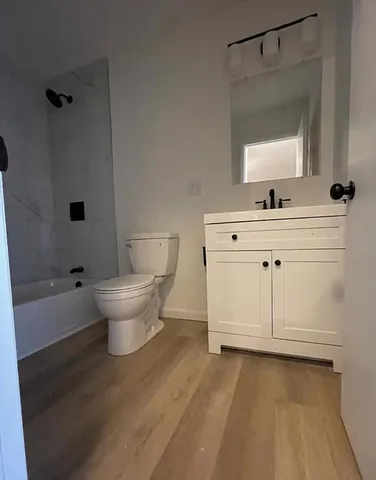 a bathroom with a sink toilet a mirror and bathtub