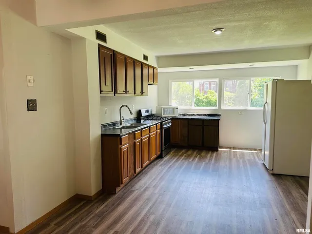 a kitchen with stainless steel appliances granite countertop a sink and wooden cabinets