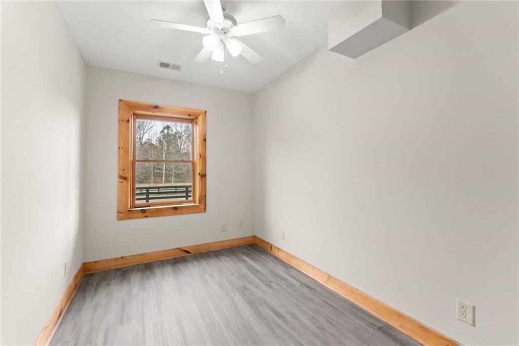 40 Benton Road Jefferson, GA 30549 - Photo 46 of 73 an empty room with wooden floor chandelier fan and window