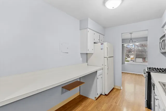 a view of kitchen with refrigerator stove and wooden floor