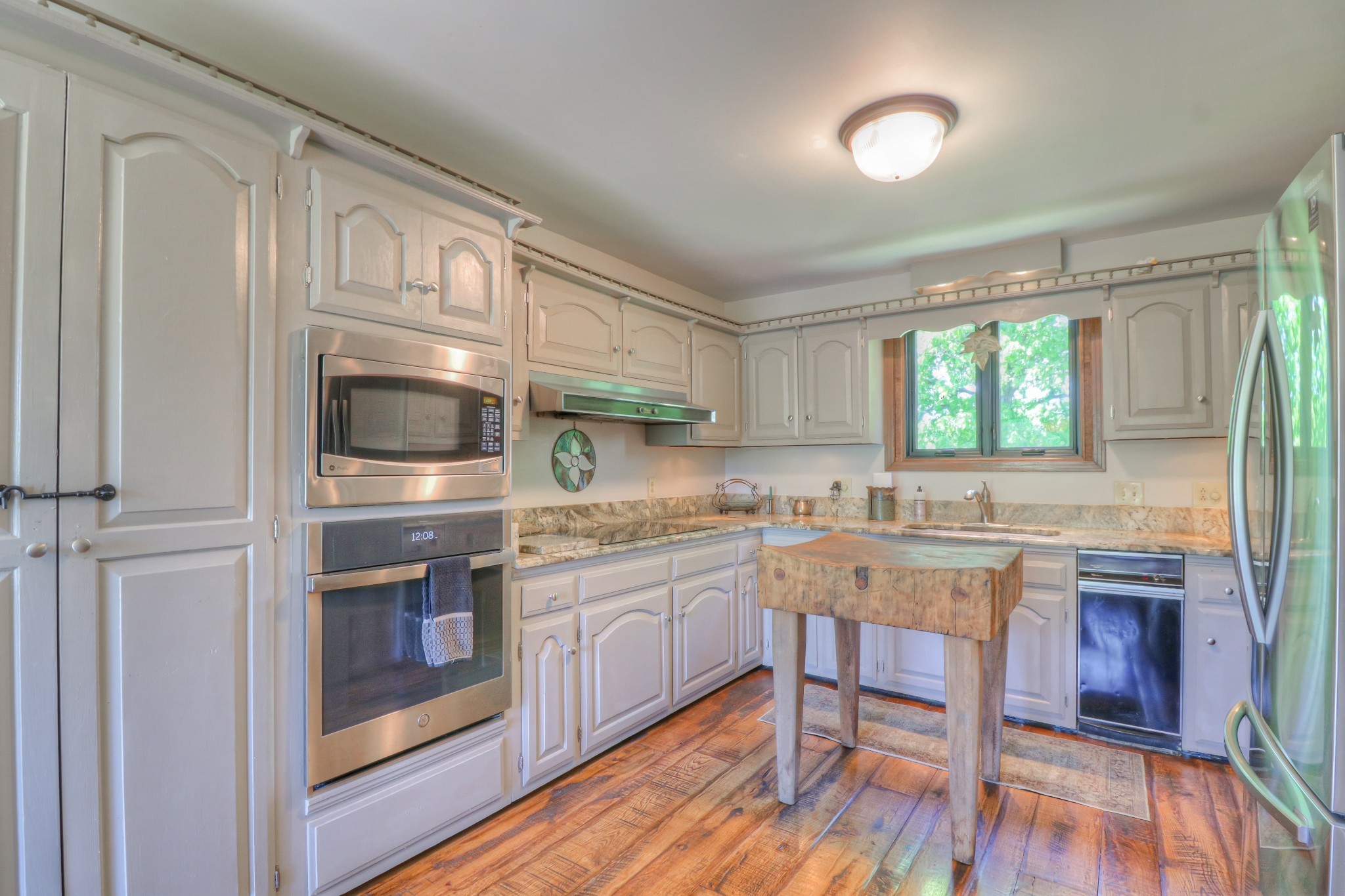 7308 Walker Road Fairview, TN 37062 - Photo 13 of 36 a kitchen with stainless steel appliances granite countertop a stove and white cabinets